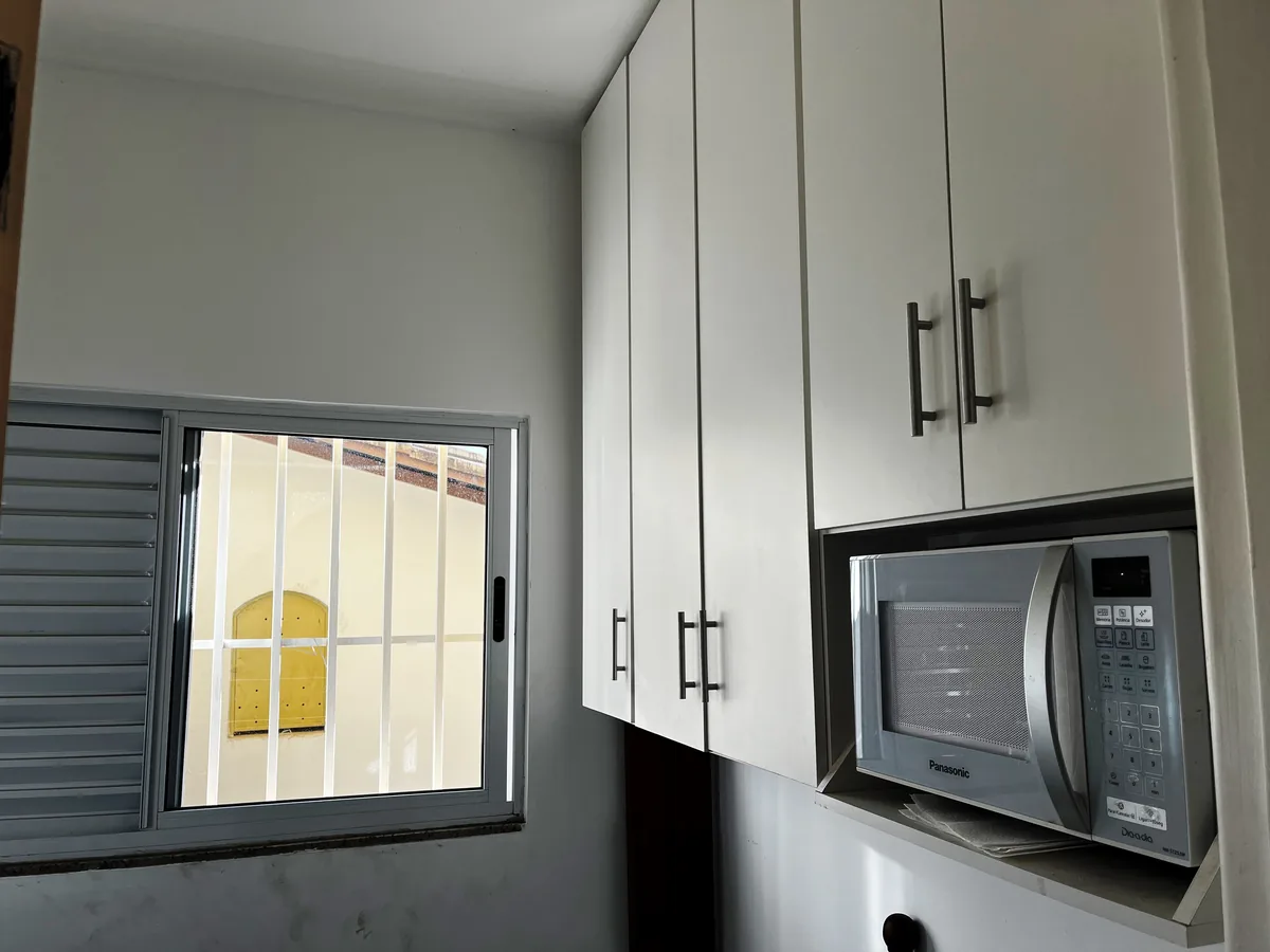 Cozinha com armários planejados do apartamento térreo no Santa Rosa, com nicho para micro-ondas.