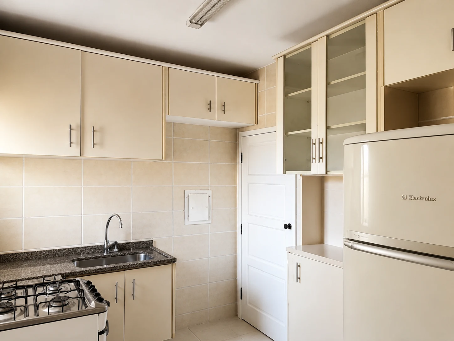 Cozinha do apartamento com armários e espaço organizado para a rotina.